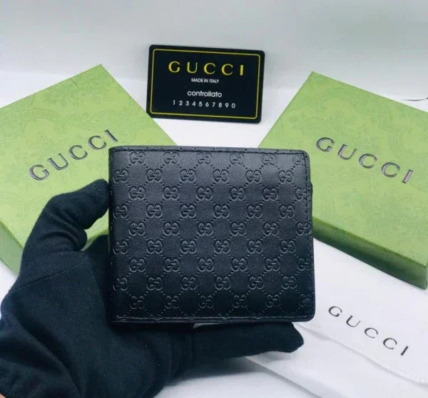 Black embossed leather wallet with GG pattern, displayed with green gift boxes and authenticity card.